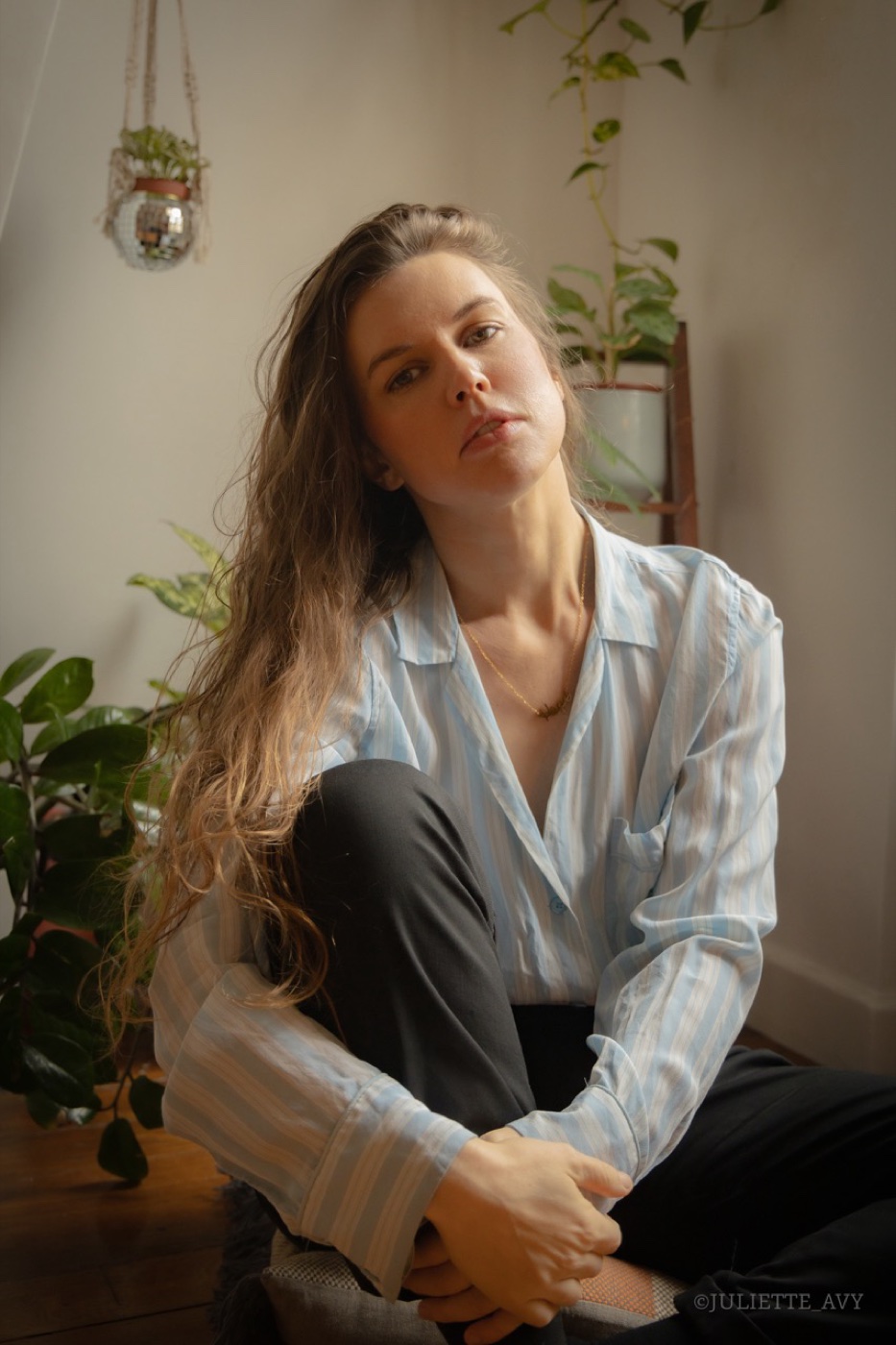 Hope Littwin at home among plants, in a striped shirt